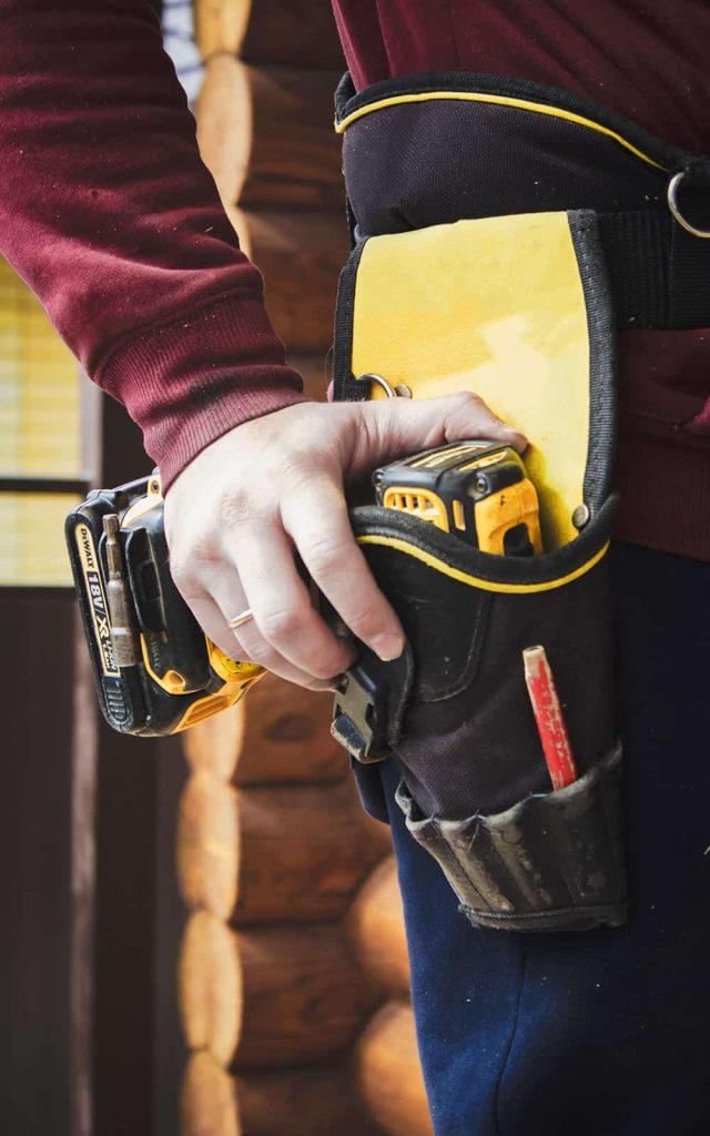 Person wearing tool belt with power drill and tools, emphasizing Texcore Construction's commitment to quality roofing services and skilled craftsmanship in Fort Worth.