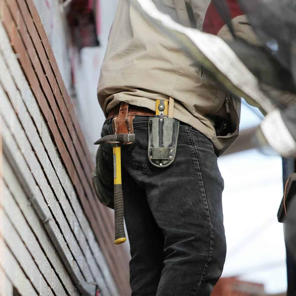 Construction worker with tools at a commercial building site, emphasizing Texcore Construction's in-house craftsmanship and project management.