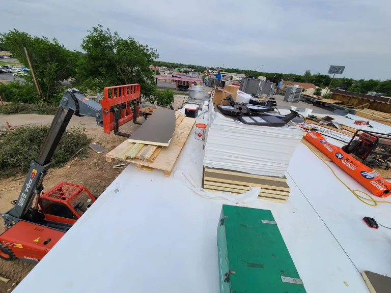 Roof insulation boards being installed on a commercial roof with a lift