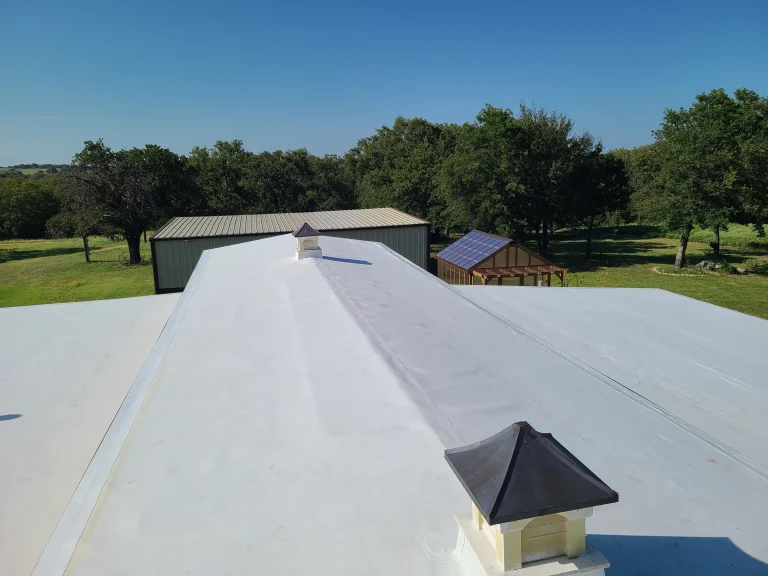 Completed white TPO flat roof on a brick commercial building
