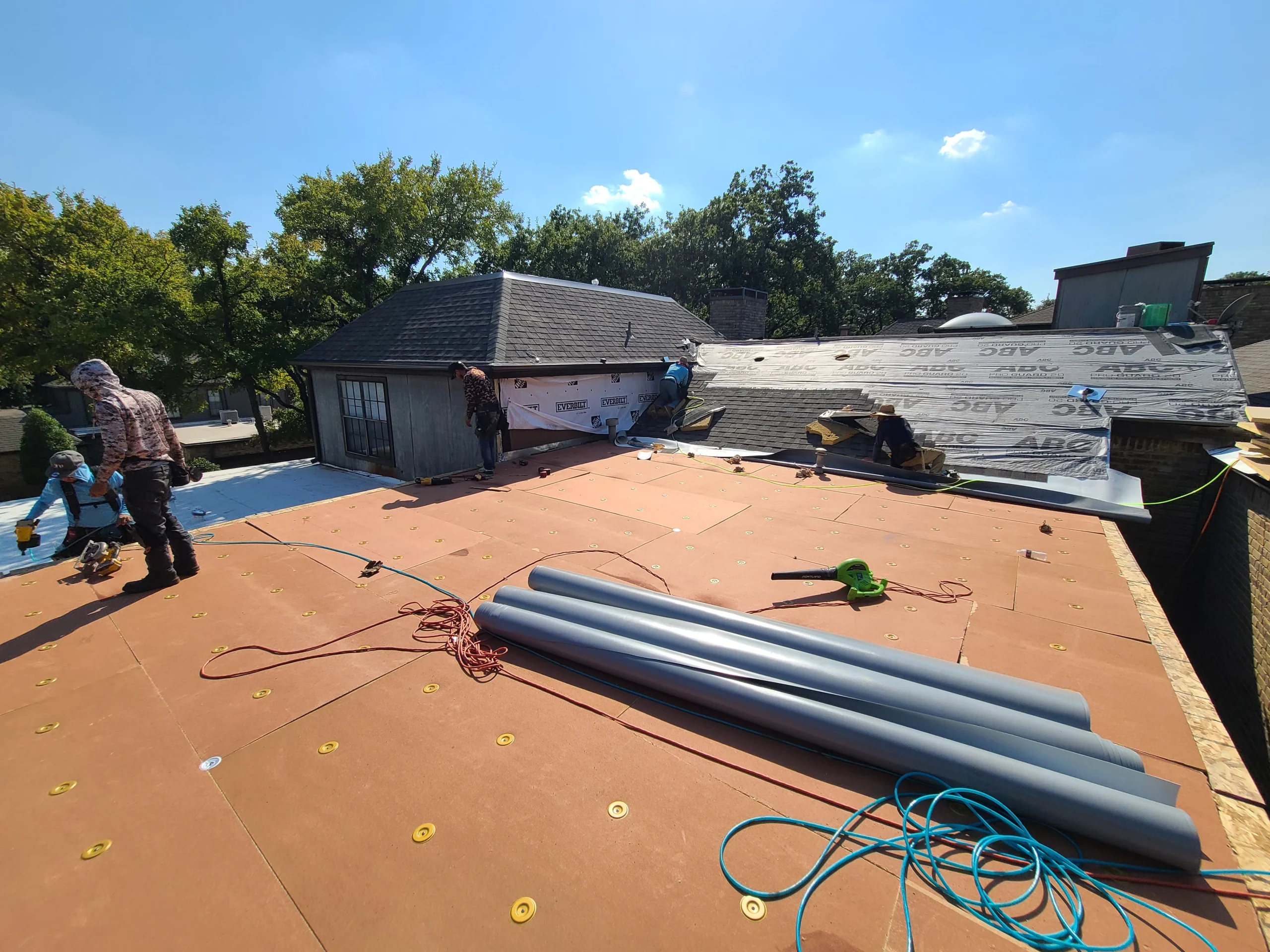 Crew installing the base layer on a commercial flat roof
