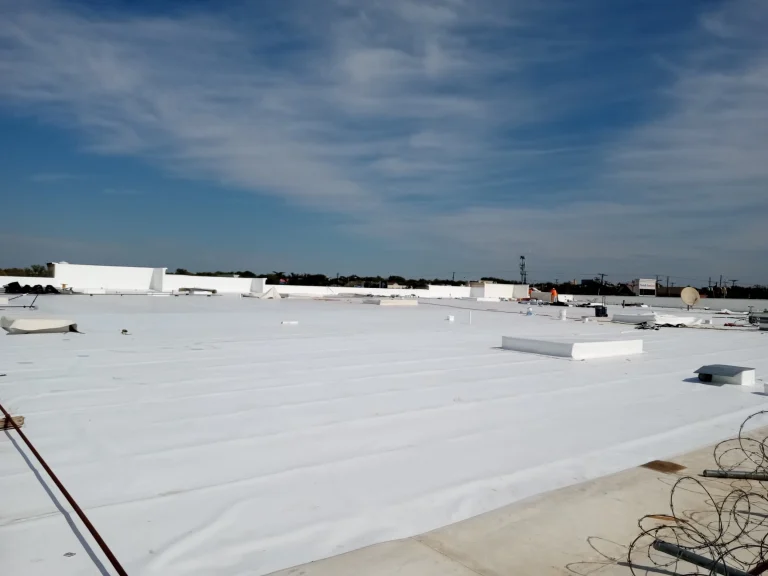 Large commercial flat roof covered in white TPO membrane